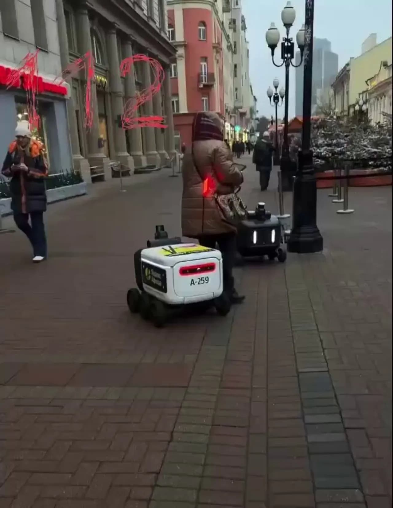 Rusya'da Sokakta Yürüyen Kadına Robot Kurye Çarptı Rusya'da Sokakta Yürüyen Kadına Robot Kurye Çarptı