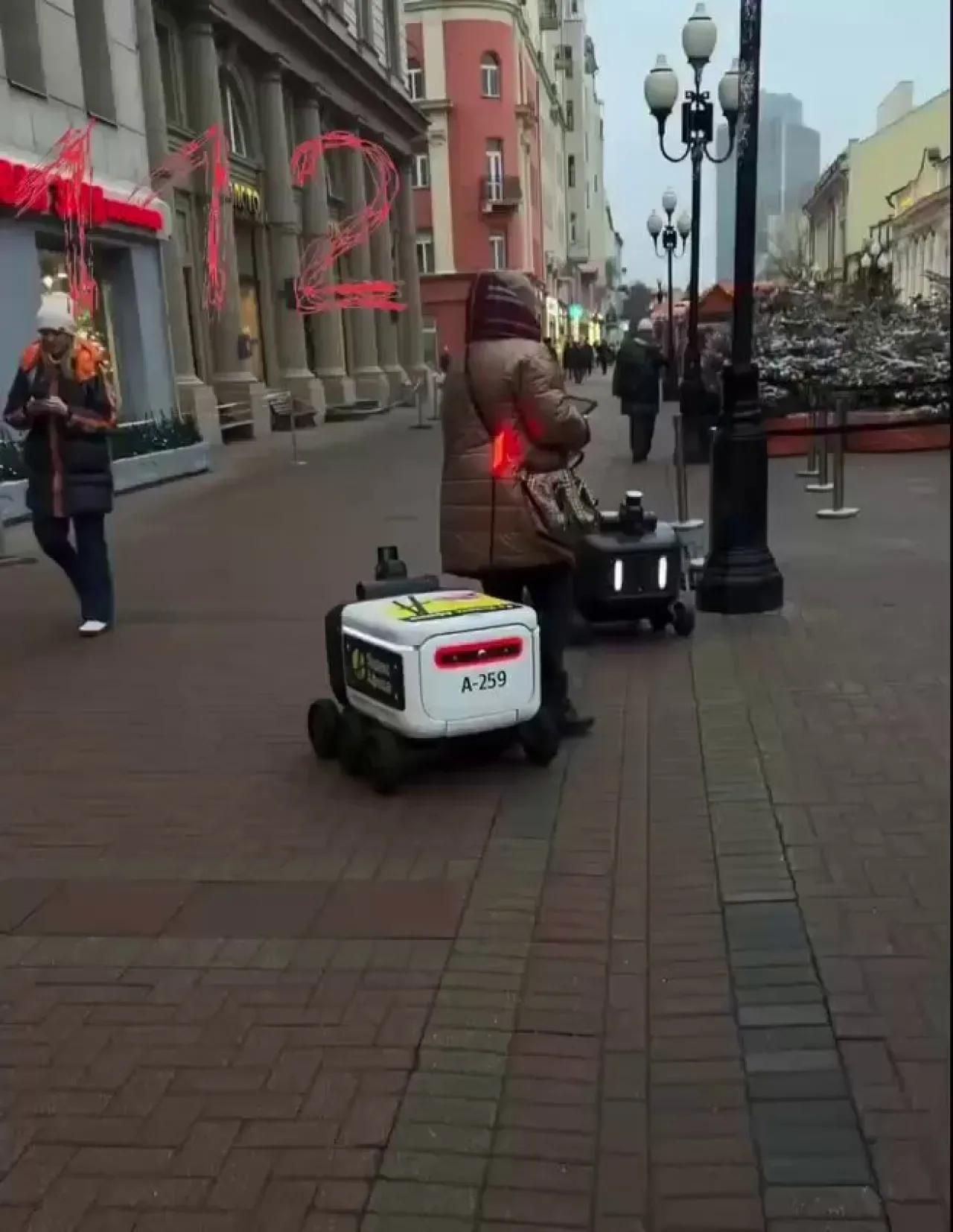 Rusya'da Sokakta Yürüyen Kadına Robot Kurye Çarptı Rusya'da Sokakta Yürüyen Kadına Robot Kurye Çarptı