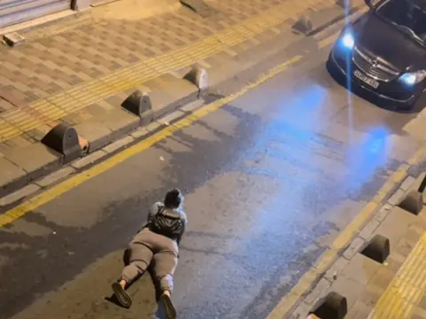 İstanbul'da Yol Ortasında Yüzüstü Yatarak Telefonla İlgilenen Kadın Görüntü u