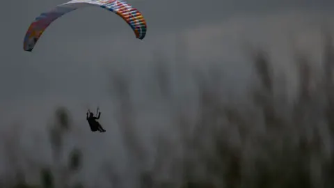 Almanya'da Korkutan Kaza: Yamaç Paraşütüyle Uçan Yaşlı Adam Ağaca Düştü Almanya'da Korkutan Kaza: Yamaç Paraşütüyle Uçan Yaşlı Adam Ağaca Düştü